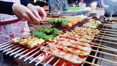 Midsection of person preparing food on barbecue grill