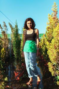 Portrait of woman standing against plants