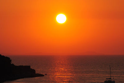 Scenic view of sea against orange sky