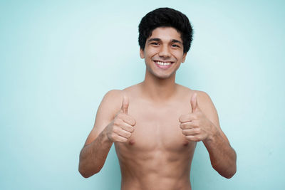 Portrait of smiling young man against blue background