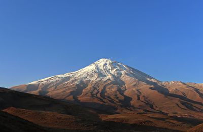 Scenic view of snowcapped mountains against clear blue sky