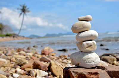 Stack of pebbles on beach against sky