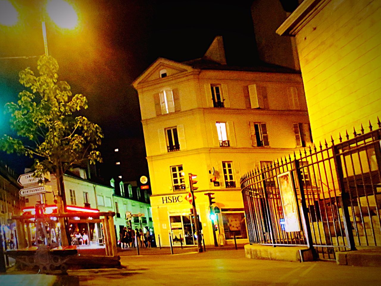 architecture, building exterior, built structure, illuminated, night, city, building, street, residential building, yellow, incidental people, railing, outdoors, lighting equipment, street light, residential structure, low angle view, sky, city life, house