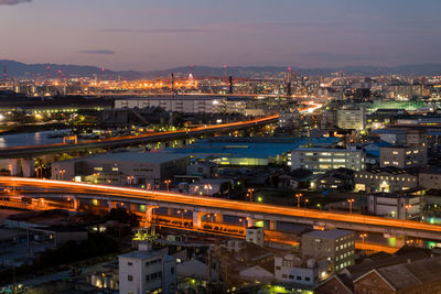 Illuminated cityscape against sky at night