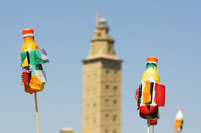 Tower of hercules and toys against sky