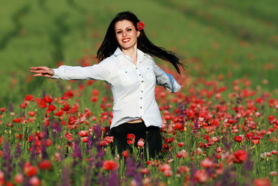 Portrait of smiling young woman standing on field