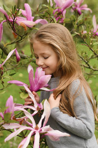 Portrait of young woman looking away by plants