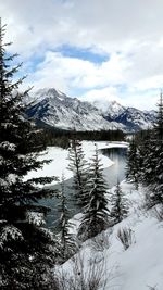 Scenic view of snow covered mountains against cloudy sky