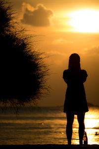 Silhouette woman standing at beach