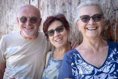 Portrait of smiling people standing by wall