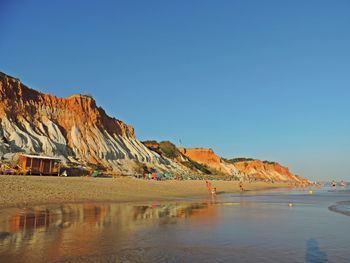 Scenic view of beach against clear blue sky