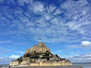 Built structure by sea against sky