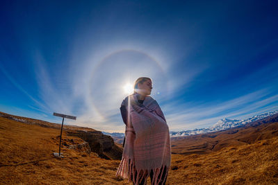 Young man standing on land against sky