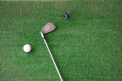 High angle view of golf ball and iron on driving range