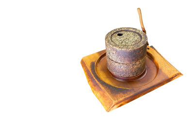 High angle view of rusty metal on table against white background