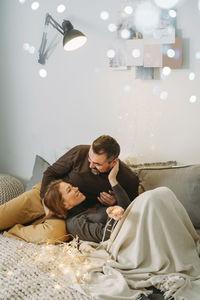 Happy couple celebrating romantic christmas eve at home. christmas interior decoration for family