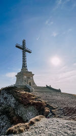 Low angle view of caraiman cross against sky in bucegi mountains
