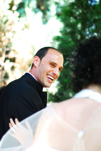 Close-up of smiling groom and bride outdoors