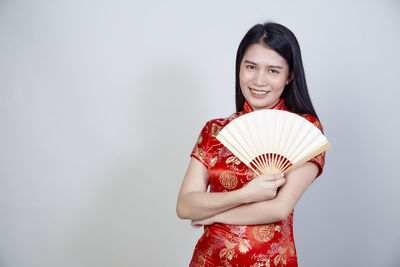 Portrait of a smiling young woman against white background