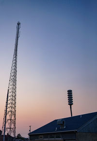 Low angle view of communications tower against sky during sunset