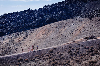 Side view of people hiking on mountain