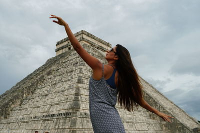 Low angle view of woman standing against sky