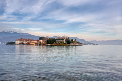 Scenic view of sea by buildings against sky