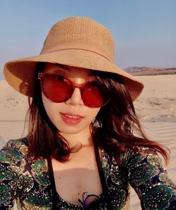 Portrait of beautiful woman wearing hat in desert