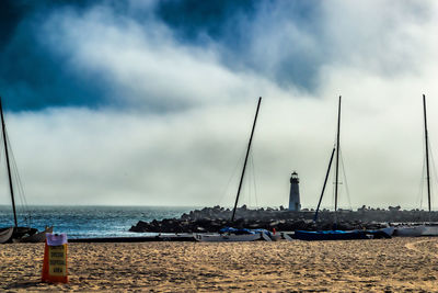 Sailboats moored on sea against sky