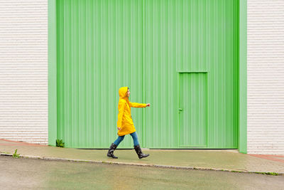 Full length of boy standing against wall