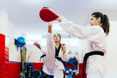 Young woman with instructor practicing martial arts