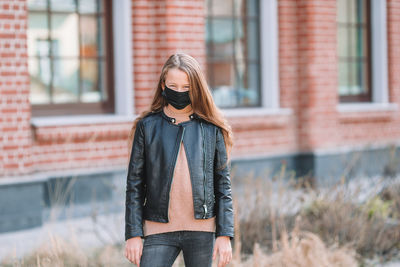 Girl wearing mask while standing outdoors