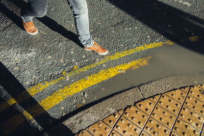 Low section of man skateboarding on road