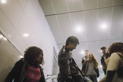 Playful male and female teenage friends having fun at mall