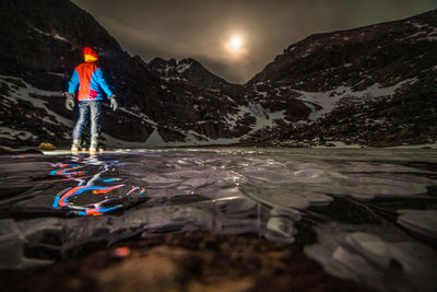 Man standing on snow against mountain at night