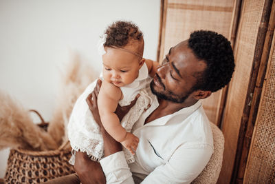 Father and son holding baby