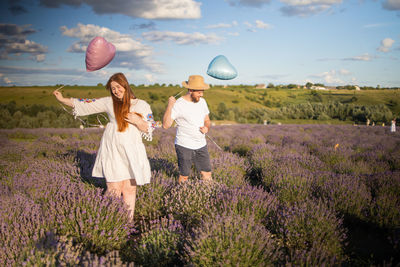 Happy couple holding airballons in lavender field