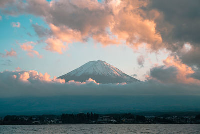 Scenic view of mountain against cloudy sky during sunset