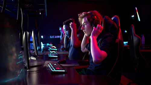 People playing video game in darkroom