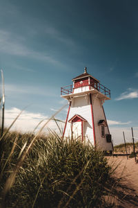 Low angle view of lighthouse on field against sky