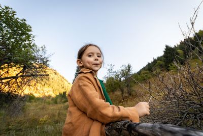 Portrait of young woman standing on field