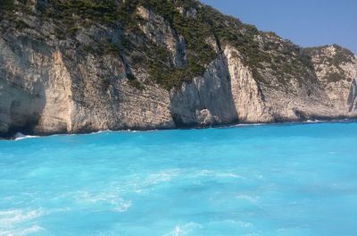 Turquoise sea water by cliff