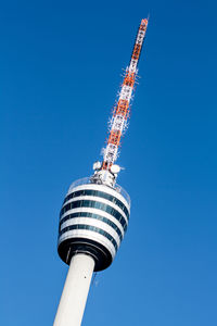 Low angle view of communications tower against blue sky