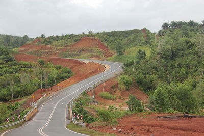 Road amidst trees against sky