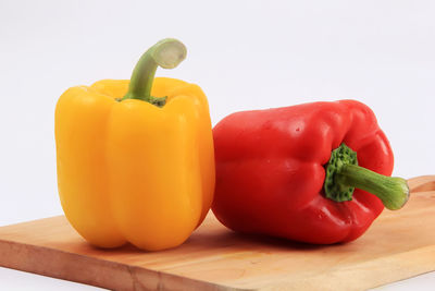 Close-up of bell peppers on table against white background
