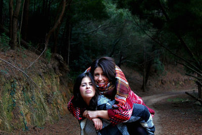 Portrait of two smiling young woman in forest