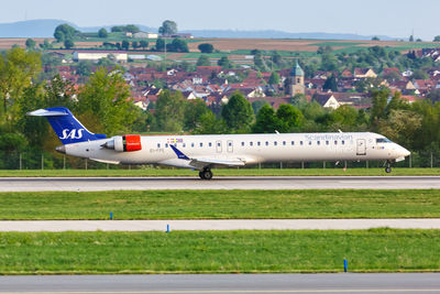 Airplane on airport runway against sky