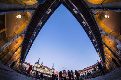 Low angle view of crowd against clear blue sky