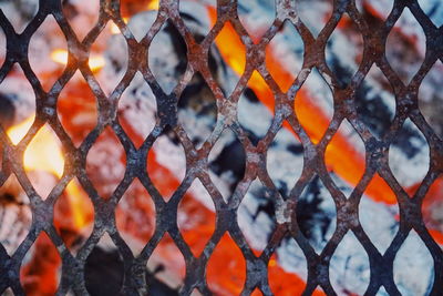Full frame shot of metallic fence against bonfire