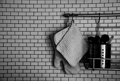 Kitchen equipment hanging on rod against tiled wall in kitchen